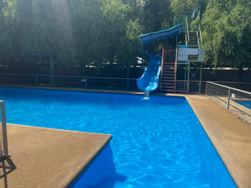 Vista cercana de una piscina azul y su tobogán